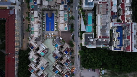 Eine-Atemberaubende-Luftaufnahme-Eines-Modernen-Wohngebäudes-Im-Herzen-Des-Geschäftigen-Playa-Del-Carmen,-Mit-Einer-Straße-Voller-Autos-Darunter