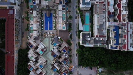 a breathtaking aerial view of a modern residential building in the heart of bustling playa del carmen, with a street filled with cars below