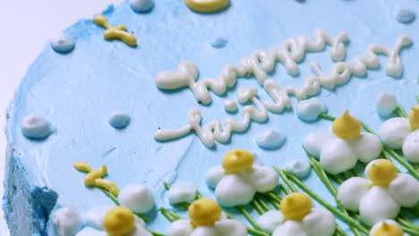 A-birthday-cake-decorated-with-dainty-flowers-and-glazed-in-pastel-colored-icing-with-the-wordings-for-a-birthday-celebration