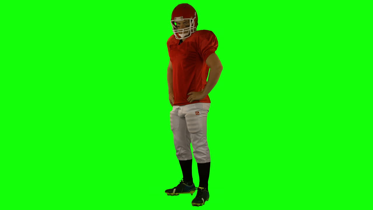 Jogador de futebol americano de vermelho posando.