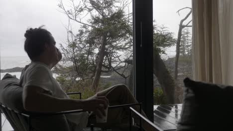 man sit on a chair to drink his hot coffee with sceni landscape outside the house