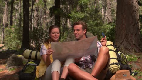 smiling couple with map on a hike in the countryside