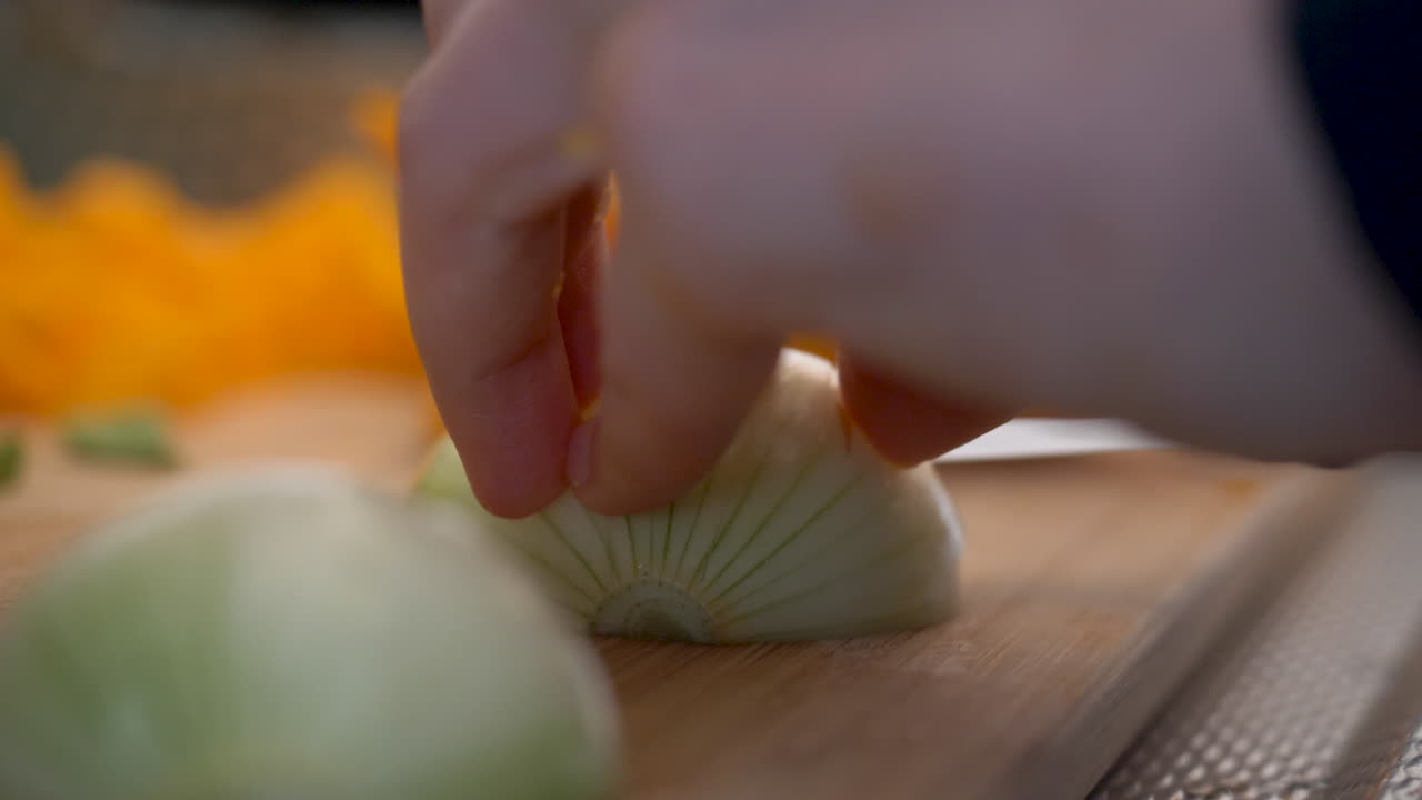Preparing onions on a wooden cutting board.