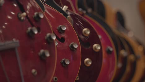 slow motion rack focus of a line of electric guitars.