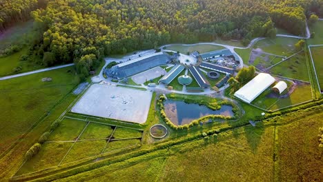 aerial shot , horses riding in an outdoor arena