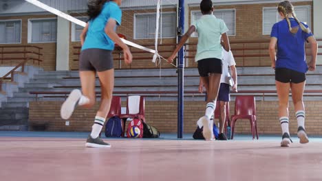 Male-coach-assisting-volleyball-players-in-exercise-4k
