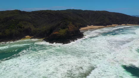 Breite-Filmische-Drohnenaufnahme-Von-Brechenden-Wellen-Und-Einer-Insel-Am-Strand-Von-Broken-Head-In-Australien