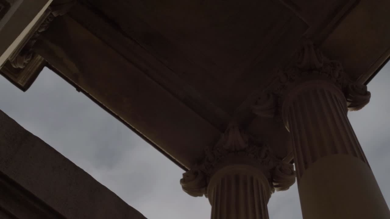 Looking up at ornate stone pillars and roof against blue skies