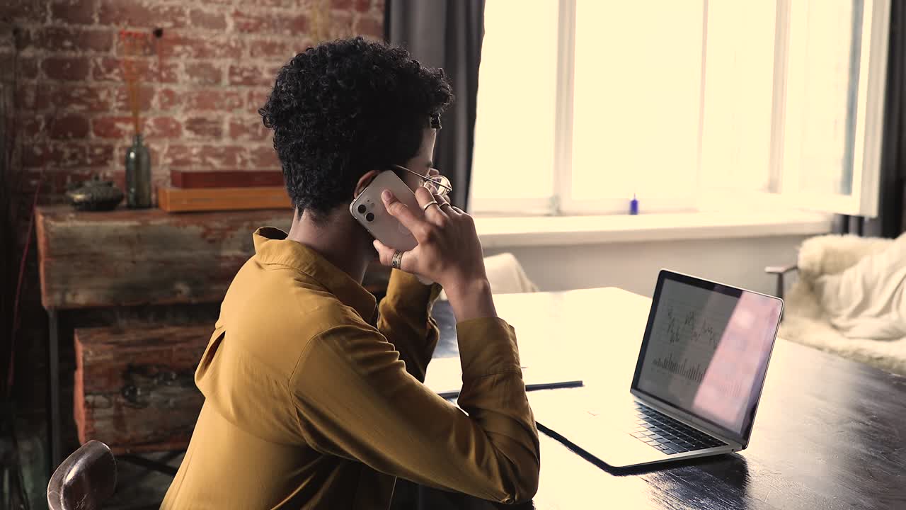 Businesswoman talks on phone, discuss financial data, shown in graphs