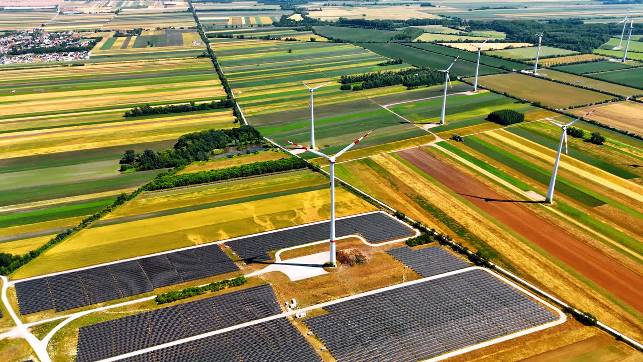 Wind and solar energy scene. Expansive fields showcase wind turbines and solar panels under clear skies in a sustainable energy installation