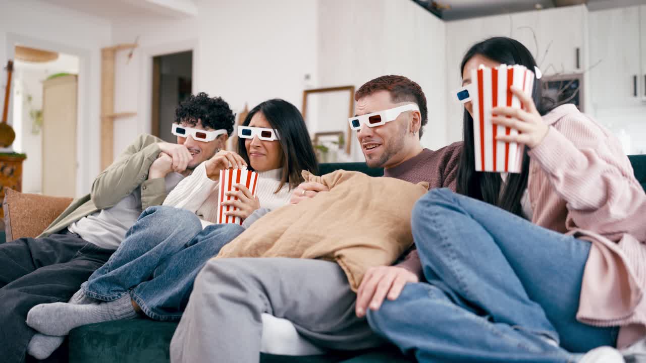 Amici che guardano un film dell'orrore con occhiali 3D e popcorn a casa