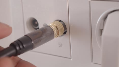 connecting a coaxial cable to a wall outlet