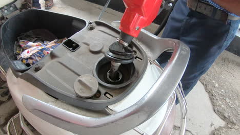 close-up-of-operator's-hand-pouring-gasoline-into