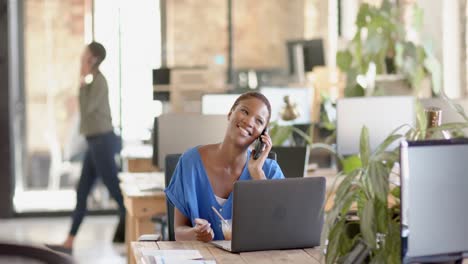 Fröhliche-Afroamerikanische-Kollegen,-Die-Auf-Dem-Smartphone-Sprechen-Und-Im-Büro-Zu-Mittag-Essen,-Zeitlupe