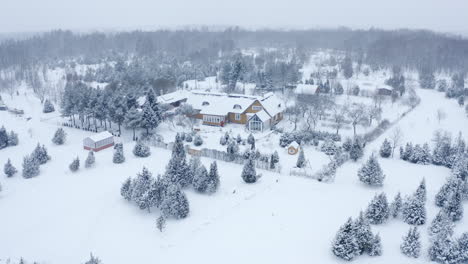 Winter-wonderland-aerial-of-a-country-house-in-a-snow-blizzard-during-Christmas