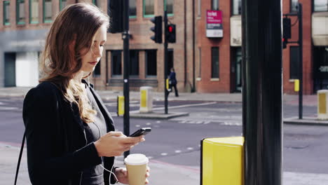 attractive business woman commuter using smartphone walking in city of london