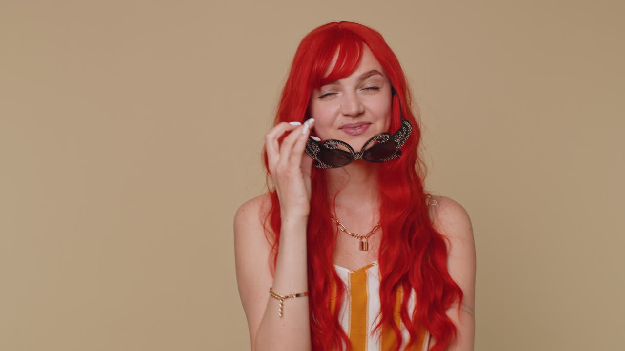 선글라스를 입고 크 을 입은 매력적인 스타일리시한 빨간 머리 소녀, 카메라를 바라보는 매력적인 미소