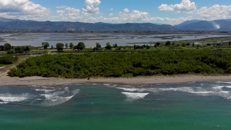 Pine-trees-and-sandy-beach-separating-turquoise-sea-from-shallow-lagoon-in-Kune,-Albania