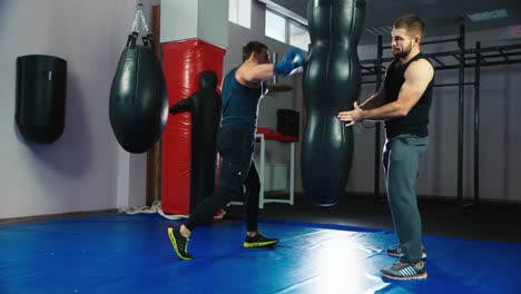 un joven boxeador practica golpes en un saco de boxeo 7