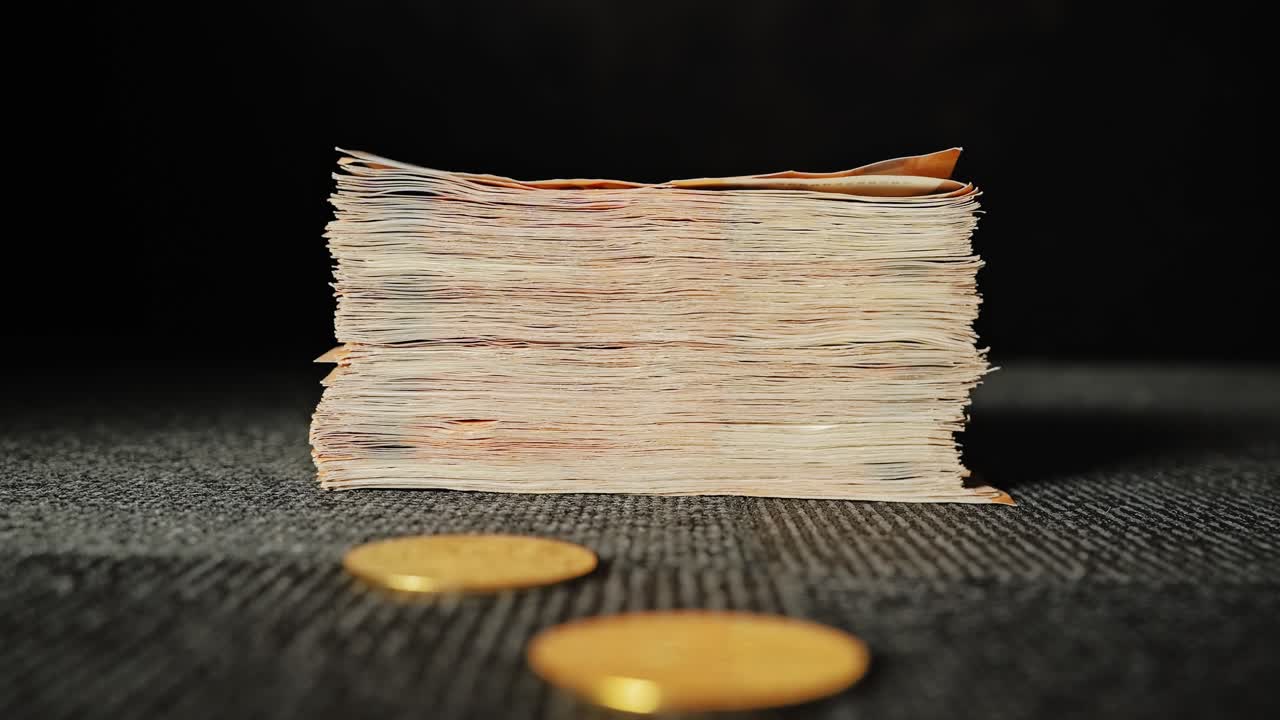 Cryptocurrency collides with traditional cash in dark studio slow motion scene