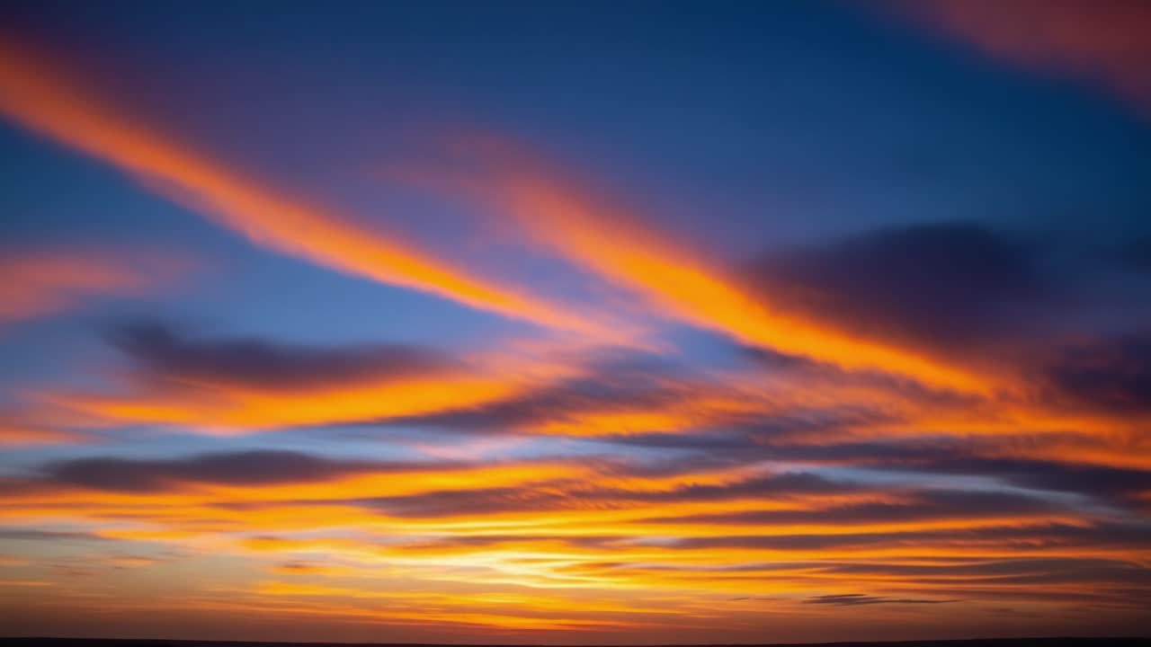 A Vibrant Sunset Sky Overlooking a Serene Landscape with Dramatic Cloud Patterns and Vivid Colors Blending Warm Hues of Orange, Red, and Blue for a Breathtaking View