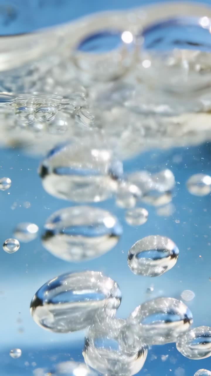 La spinta di galleggiamento spinge un gruppo di bolle verso l'alto, le bolle si deformano, si uniscono e rompono la superficie, a scopo scientifico.