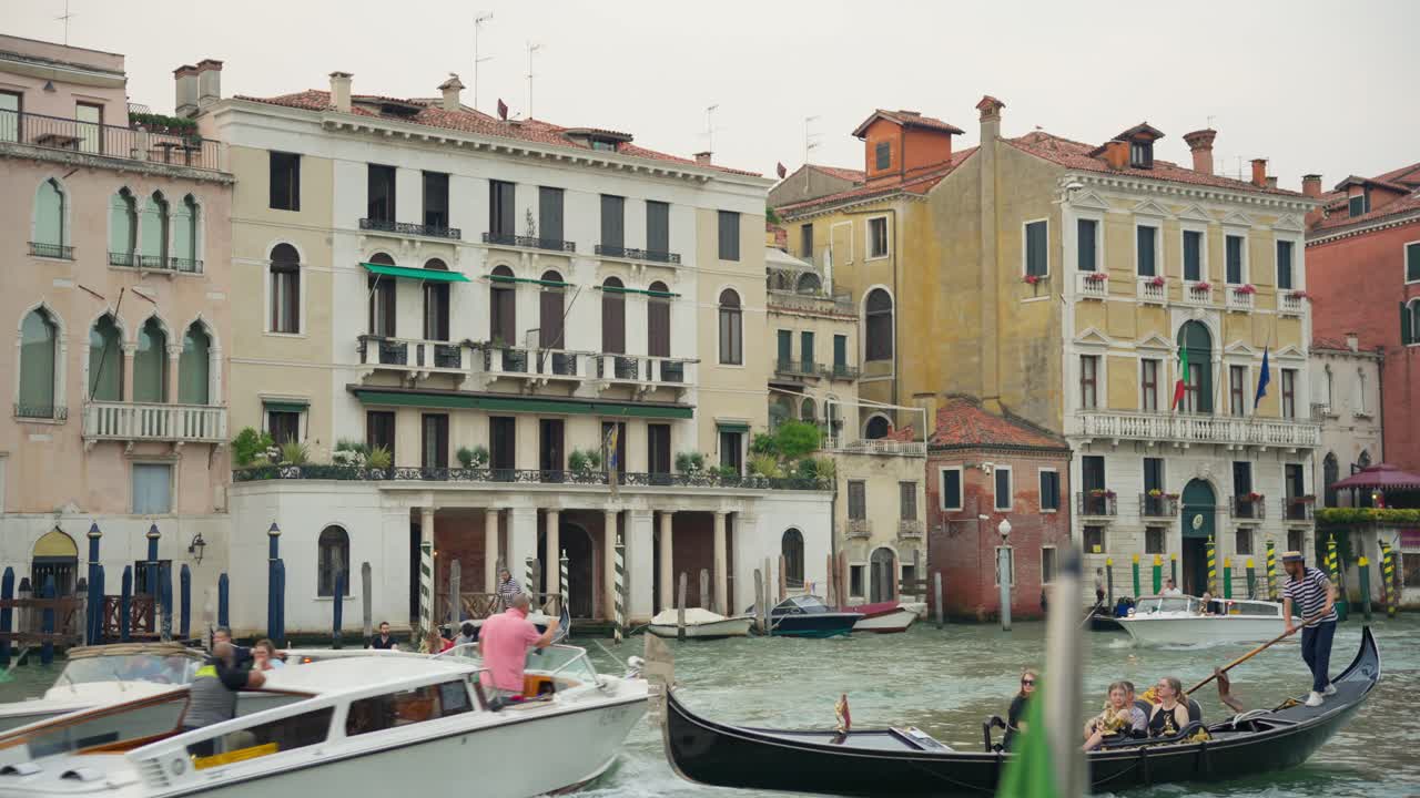 Traditional Gondola Boats Sailing In Front Of Palazzo Sernagiotto, Cannaregio On The Grand Canal In Venice, Italy. Slow Motion Shot