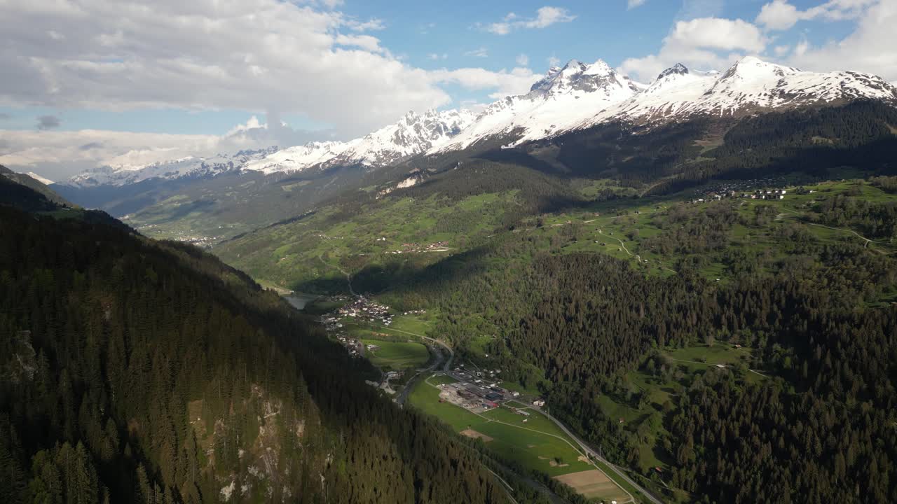 vista aérea del valle en obersaxen, graubünden, suiza, rodeado por una cordillera nevada