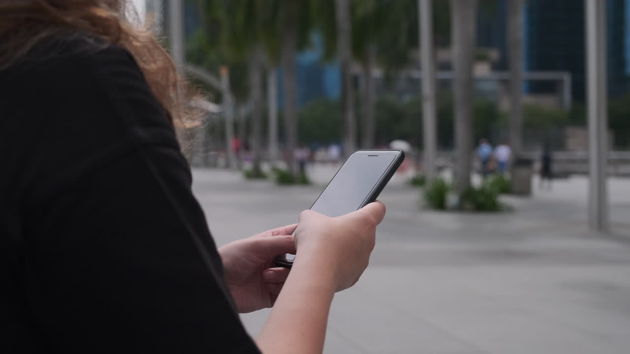 mujer usando un teléfono inteligente en una ciudad