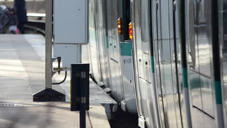 modern white and green tram going out of the station