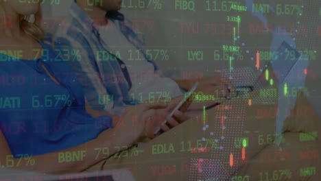 animación de datos financieros y gráficos que se mueven sobre mujeres y hombres usando teléfonos inteligentes y computadoras portátiles