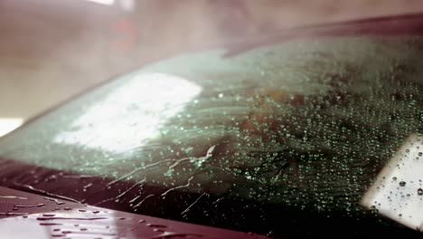 spraying water washing off car windshield