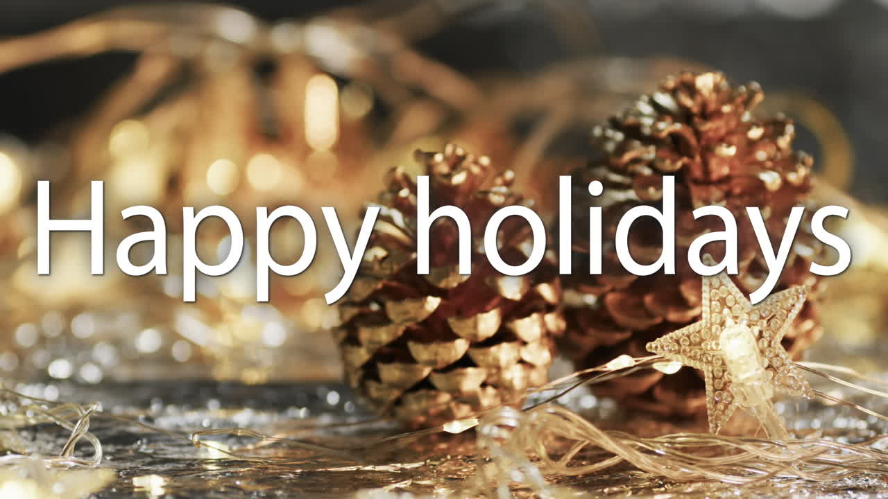 Happy holidays text in white over pine cones and christmas decorations