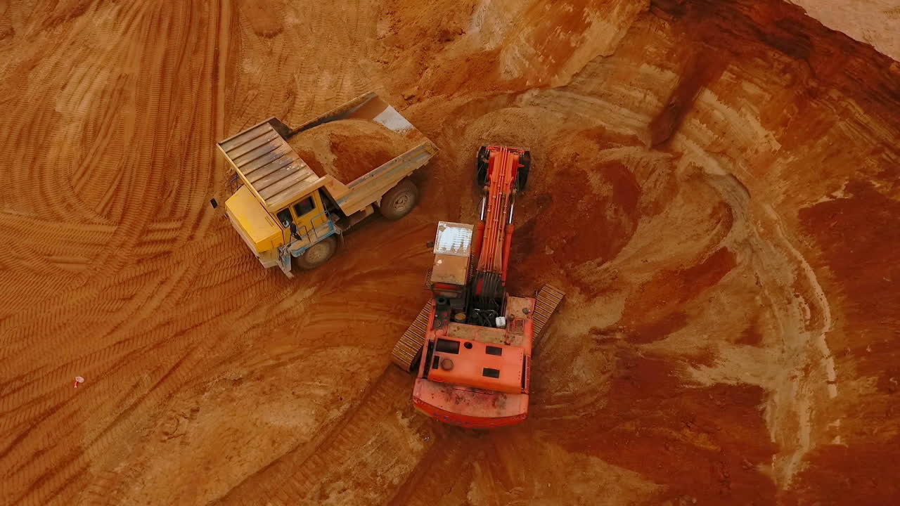 Excavator loading mining truck at sand quarry. Sand mining industry