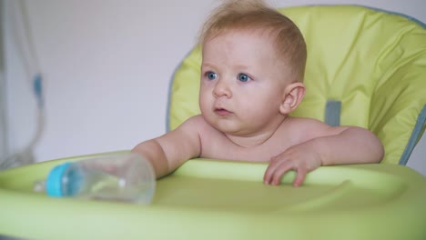 mother-and-little-boy-sitting-in-green-highchair-at-home