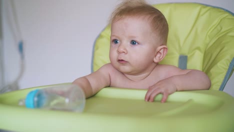 mother and little boy sitting in green highchair at home