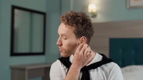 A-young-man-uses-a-spray-to-clean-his-ear-and-cotton-swabs