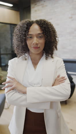 vertical video of portrait of happy biracial businesswoman with arms crossed in slow motion