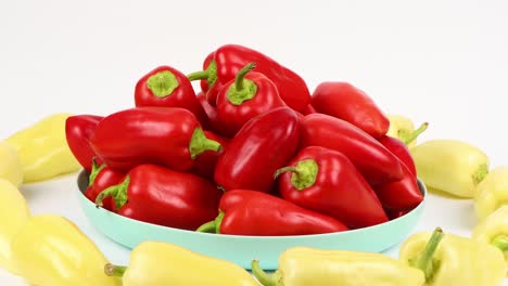 plate red sweet peppers and sweet yellow peppers in row on white background. loop motion. side view. rotation 360.