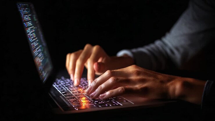 A focused individual immersed in their work, skillfully typing on a illuminated laptop keyboard in a dimly lit environment, showcasing dedication, technology, and the art of programming or content creation