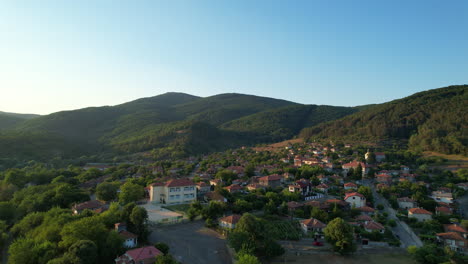 drone shot over bulgarian village into hills and woods 01