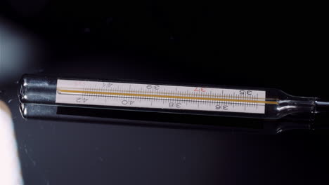 Close-up of Medical Thermometer on Black Background