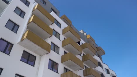 moderno bloque de pisos con balcones en un día soleado con cielo azul, camión a la izquierda