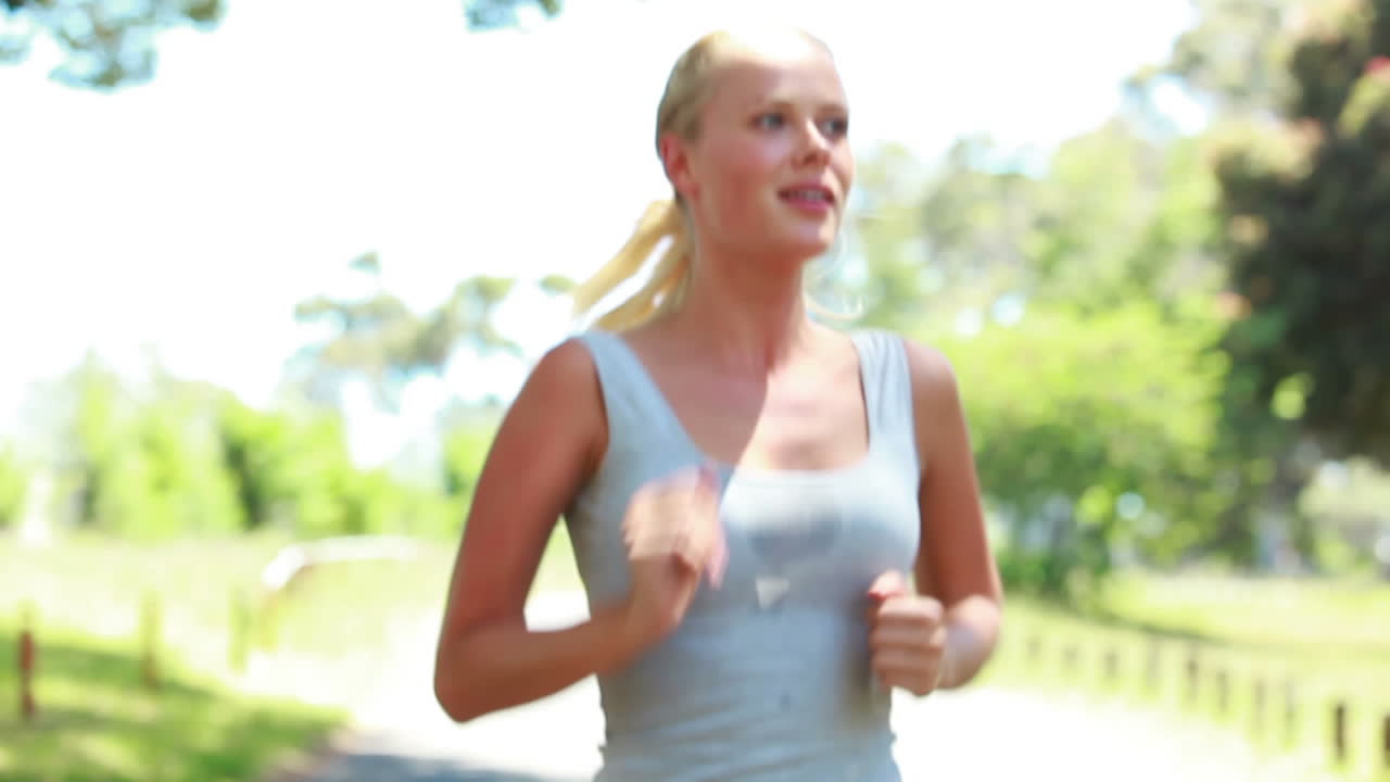 카메라 앞에서 달리면서 공원에서 조하는 여자