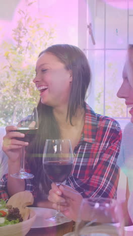 animation of bokeh over happy caucasian female and male friends drinking wine and talking