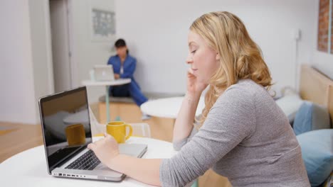 Female-executive-using-laptop-while-talking-on-mobile-phone-4k