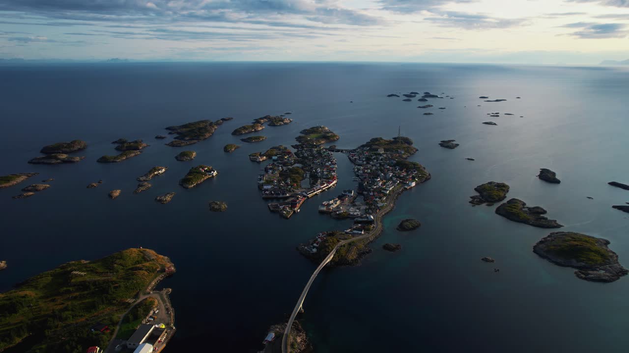 Henningsvaer, Lofoten, Norway. High altitude aerial drone shot of colorful homes at rocky coastline.