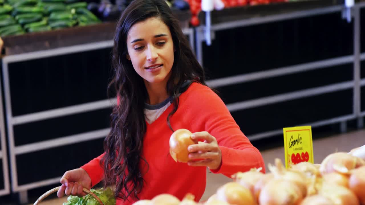 mujer seleccionando verduras de la sección orgánica