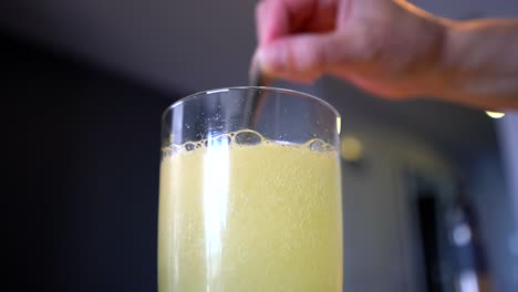 mixing power into water to create fizzy yellow lemon flavoured liquid drink