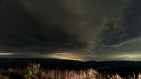 paisaje nublado nocturno sobre las montañas - lapso de tiempo